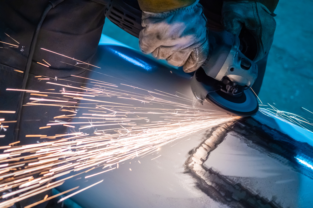 man,polishes,metal.,master,works,with,a,grinding,machine.,leveling